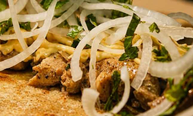 A fresh chicken paratha with onions and herbs