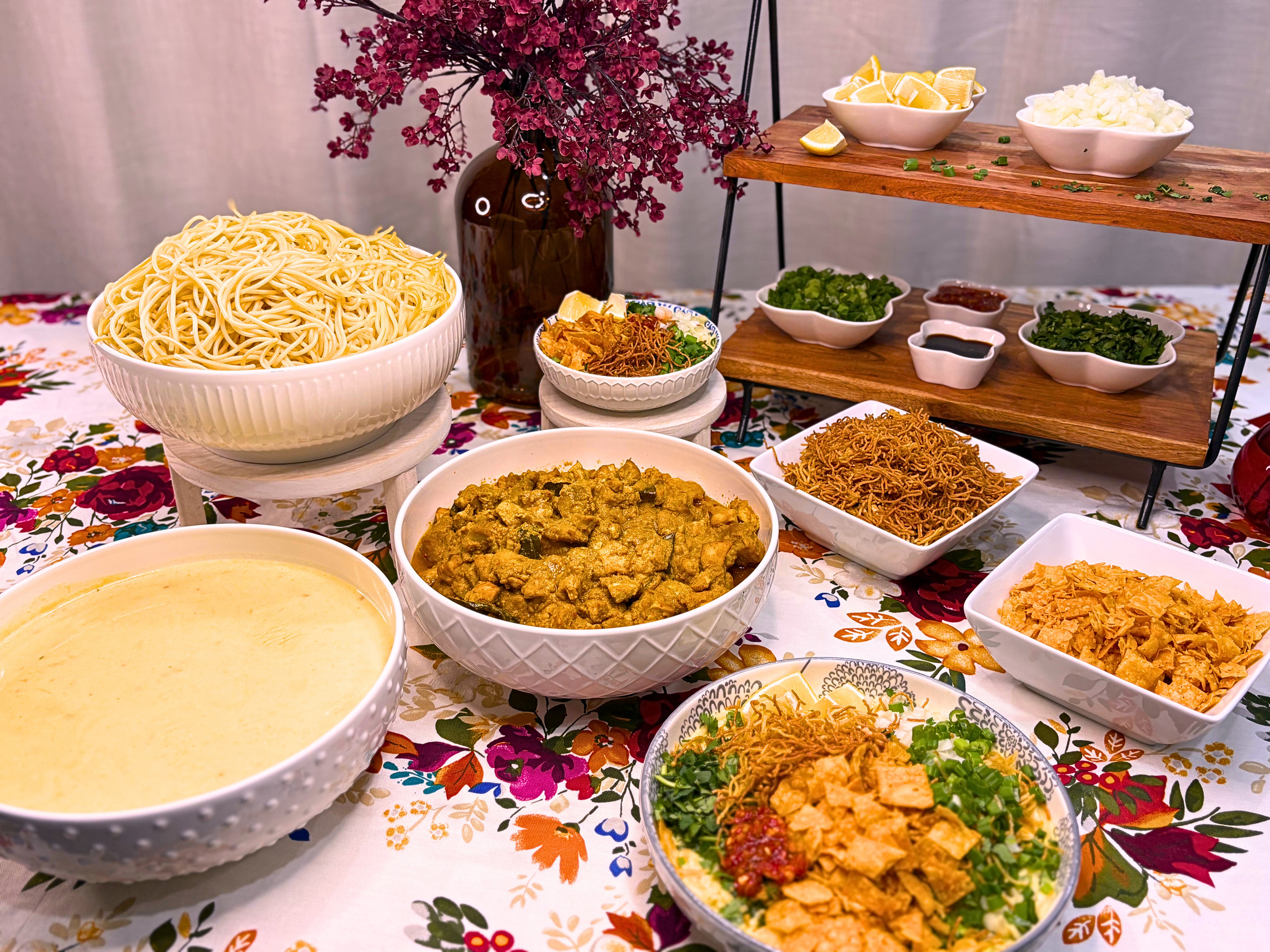 Rollup Khausay Bar with chicken, curry, noodles, and a spread of fresh toppings and sauces