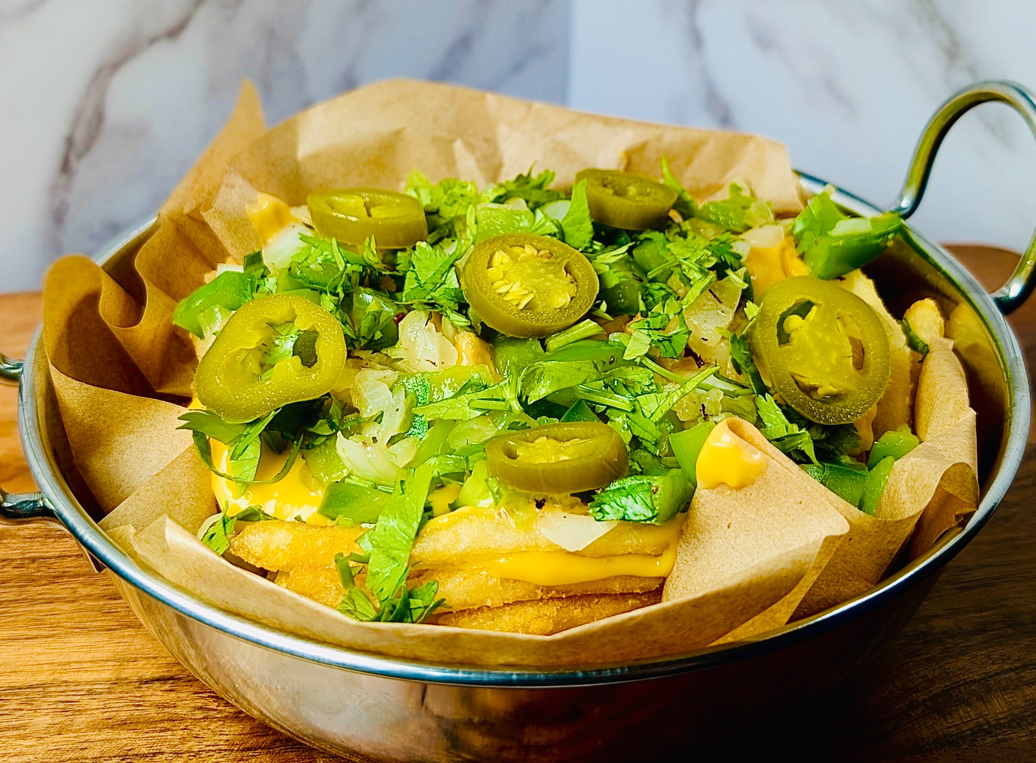 Loaded fries with cheese sauce, peppers, onions, cilantro, and jalapeños